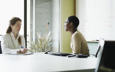 two-businesswomen-in-discussion-in-conference-room-96158082-58fa6a413df78ca1591e1da7