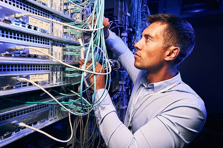it technician working on panel of cables